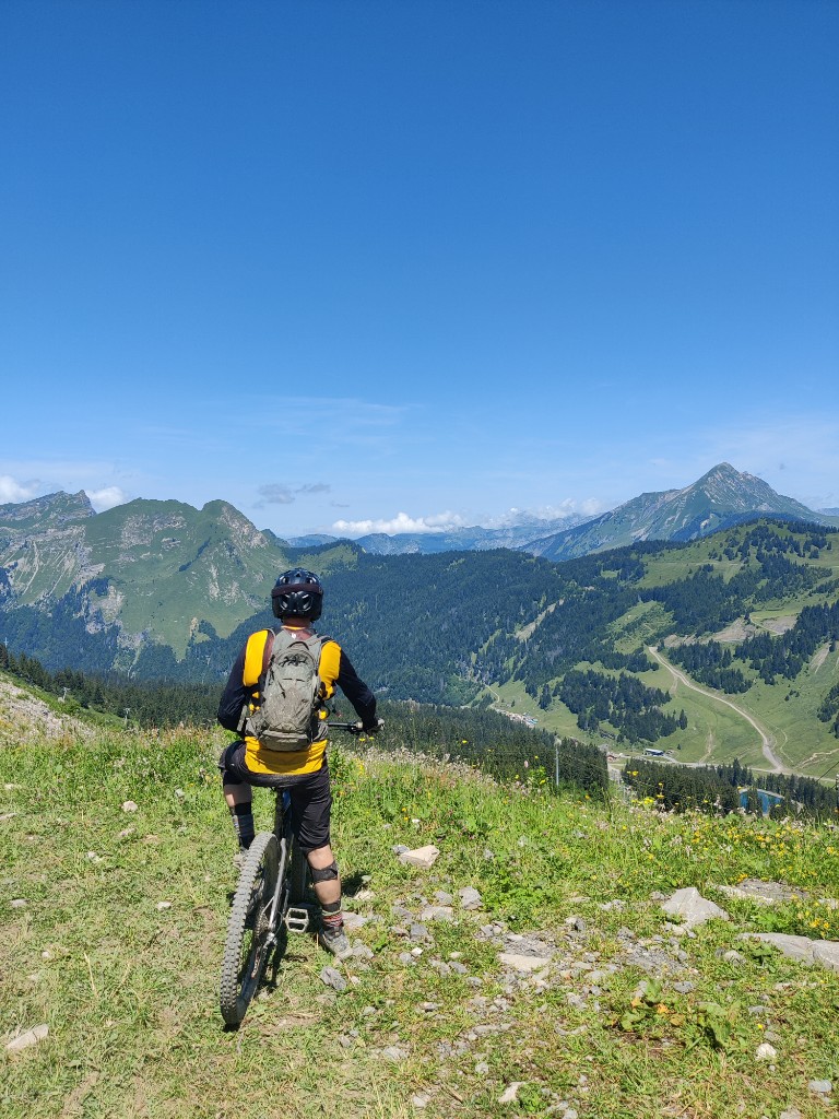 Mountain biking on a ridge above forested valleys and blue sky