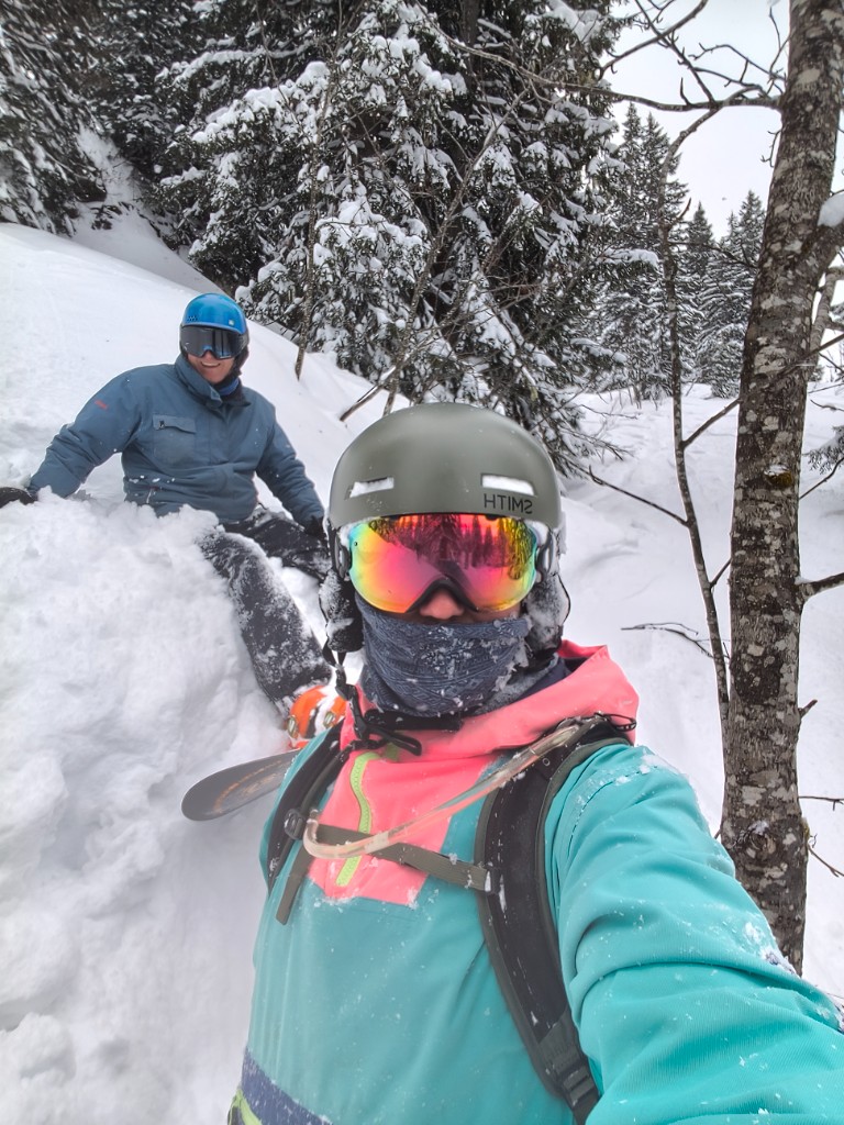 Snowboarding in the trees with winter kit and reflective goggles